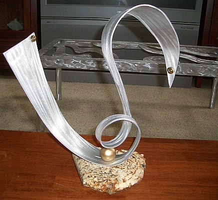 abstract sculpture and a tabletop sculpture in brushed aluminum and granite
